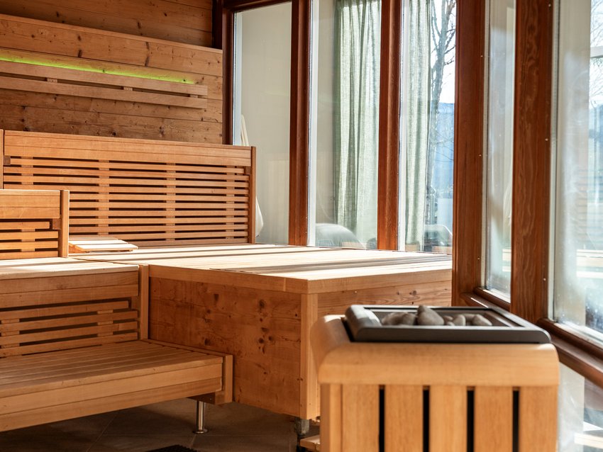 Your spa hotel in Allgäu: Allgäu Sonne Bright sauna interior with wooden benches and large windows with a view