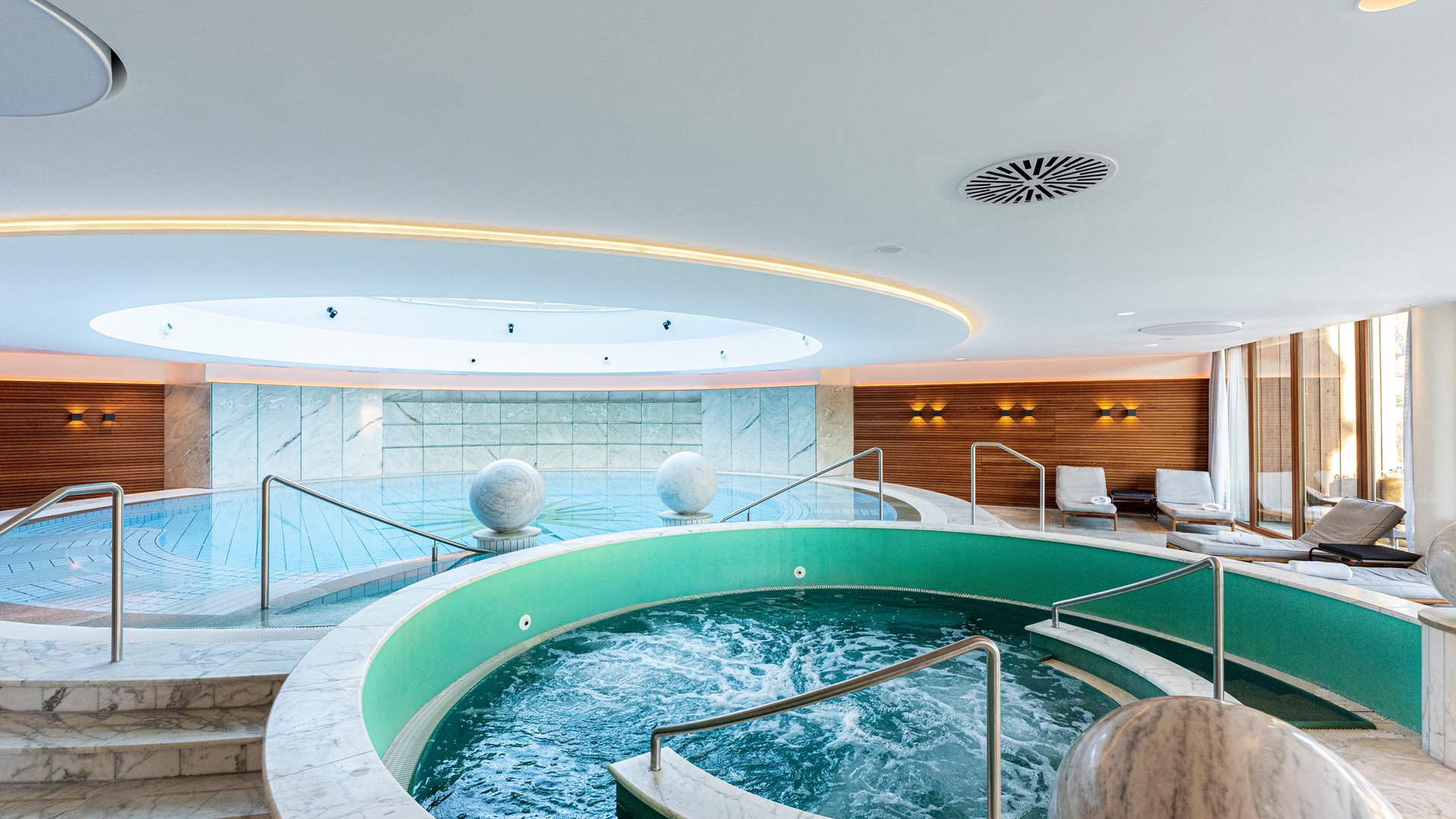Moderner Spa-Bereich mit Whirlpool, Schwimmbecken und Liegestühlen