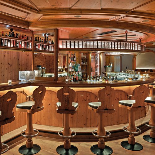 Gemütliche Bar mit Holztheke und Stühlen im rustikalen Stil