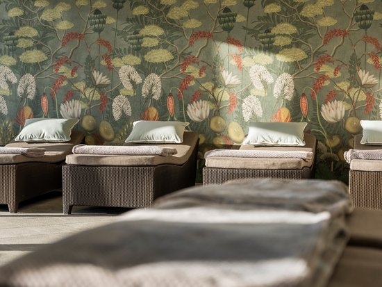 Your spa hotel in Allgäu: Allgäu Sonne Relaxing lounge chairs with pillows in front of a floral patterned wall