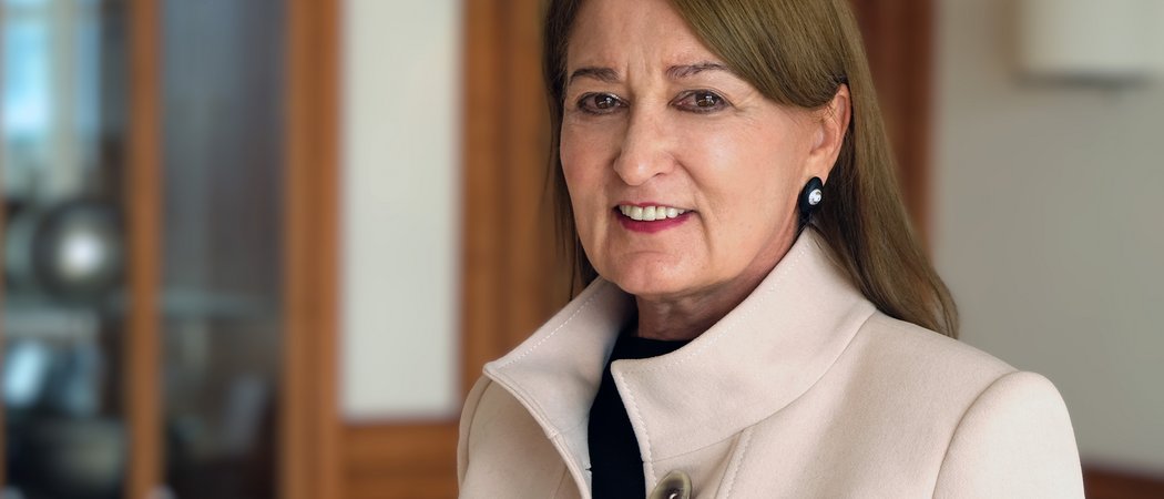 Porträt einer älteren Frau mit beige Mantel in einem Innenraum