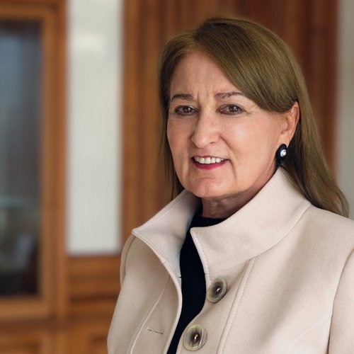 Porträt einer älteren Frau mit beige Mantel in einem Innenraum