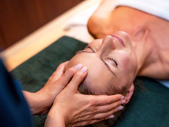 Your spa hotel in Allgäu: Allgäu Sonne Woman receiving a relaxing head massage in a spa setting