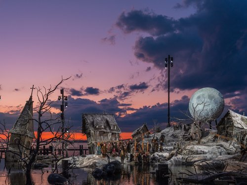 Theaterszene mit altertümlichen Häusern, Schauspielern und großer Mondkulisse bei Sonnenuntergang
