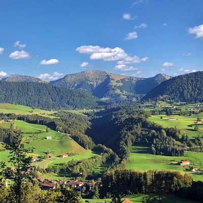 Green hills and mountains under blue sky with scattered clouds
