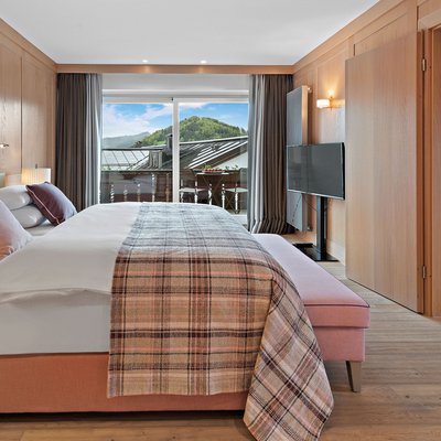 Modernes Hotelzimmer mit Doppelbett, Balkon und Bergblick