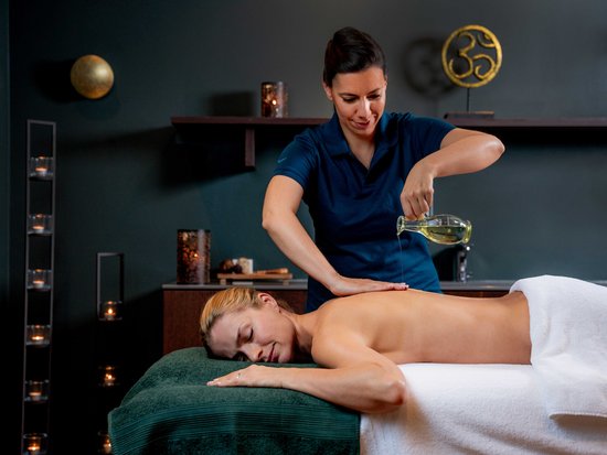 Woman receiving relaxing back massage with oil in spa setting