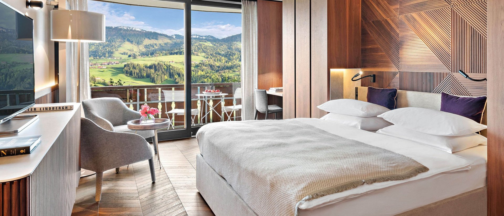Modernes Hotelzimmer mit Holzakzenten und Bergblick vom Balkon