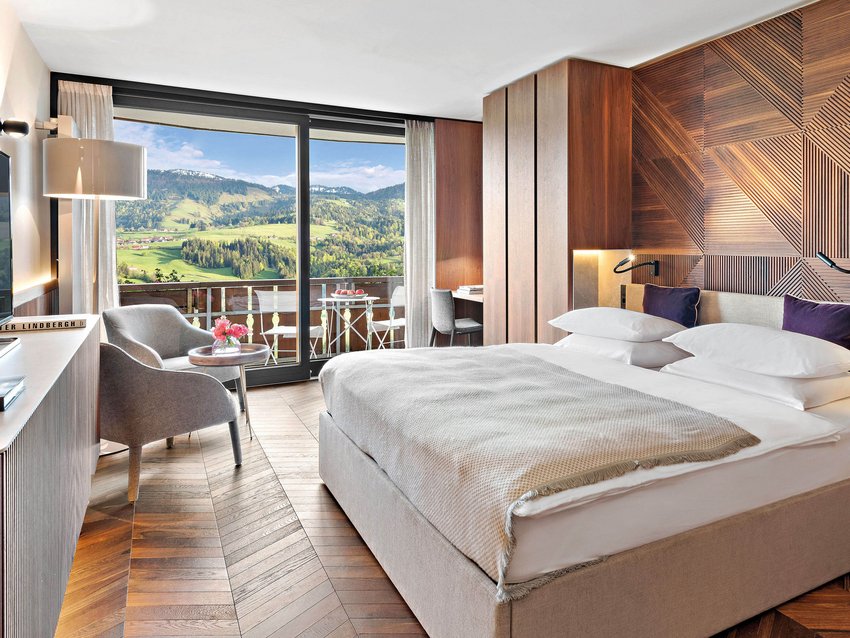 Modernes Hotelzimmer mit Holzakzenten und Bergblick vom Balkon