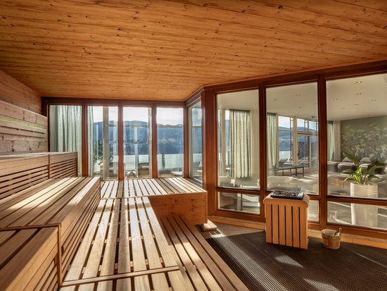 Your spa hotel in Allgäu: Allgäu Sonne Modern sauna room with wooden panels and panoramic windows showing a view
