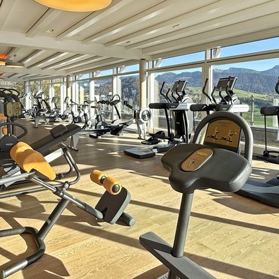 Bright gym with modern equipment and panoramic windows showing mountain views