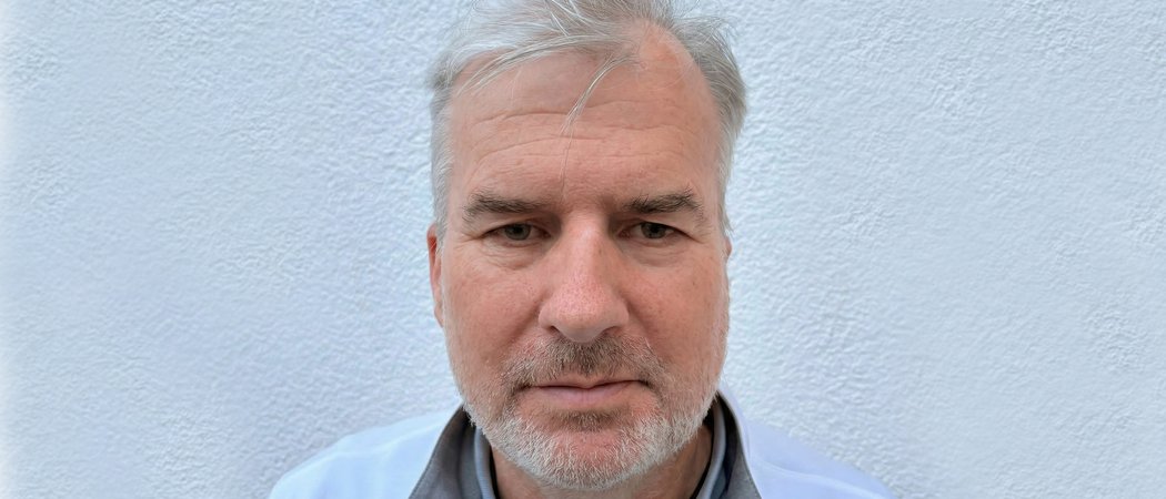 Porträt eines älteren Mannes mit grauen Haaren vor weißer Wand