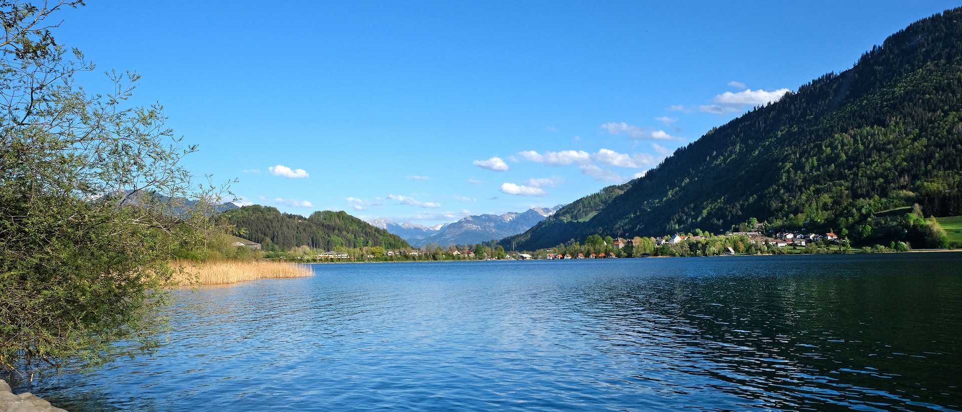 Running Camp im Allgäu Blick auf einen See mit Bergen und klarem blauen Himmel im Hintergrund