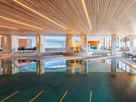 Your spa hotel in Allgäu: Allgäu Sonne Bright spa area with indoor pool, lounge chairs, and wooden ceiling
