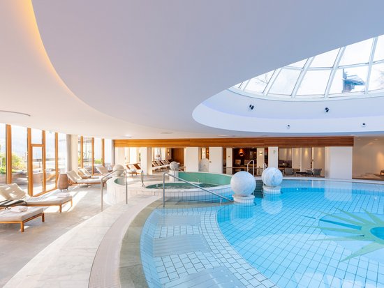 Your spa hotel in Allgäu: Allgäu Sonne Bright spa area with pool, lounge chairs, and large skylight dome