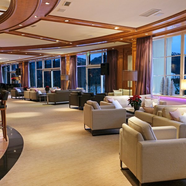 Luxuriöse Hotellobby mit bequemen Sofas und großen Fenstern mit Bergblick